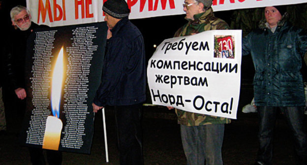 Action in memory of Dubrovka casualties and victims, Moscow, Chistoprudny Boulevard, October 26, 2009. Poster running: "We don't trust the authorities!"; poster on the right: "We demand compensations to Nord-Ost victims!". Photo by the "Caucasian Knot"