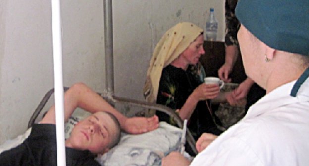 Teenager beaten by militiamen in the district hospital. His mother Aishat Guseinova is behind him. Dagestan, Shamil District, July 2010. Photo by the HRC "Memorial": www.memo.ru