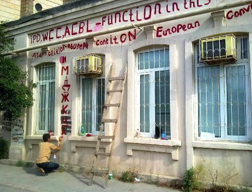  Employee of the Institute for Peace and Democracy (IPD) inscribes the building as follows: "IPD, Women's Crisis Centre and Association for Ban of Landmines work in this building. This house is property of Leila Yunus and is protected by the Constitution of Azerbaijani Republic, European Convention on Human Rights and World Declaration of Human Rights", Azerbaijan, Baku, June 13, 2011. Photo by press service of the IPD