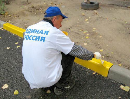 A campaigner of the "New Yards of United Russia" painting curbs in the yard of No. 60 in Kommunisticheskaya Street in the Lenin District of Astrakhan, October 13, 2011. Photo by Vyacheslav Yaschenko for the "Caucasian Knot"