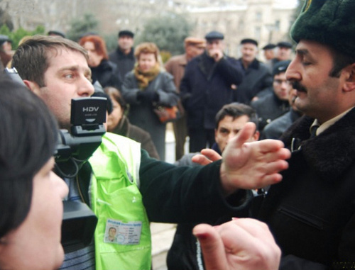 Репортер и полиция на митинге обманутых дольщиков перед зданием
 администрации президента Азербайджана. Баку, 18 января 2012 г. Фото:
www.irfs.az