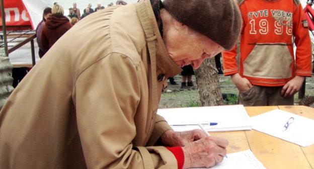 A resident of Sochi signs resolution of the rally for protection of natural beaches and parks of the Imereti Lowland against commercial developments. Sochi, April 10, 2012. Photo by Svetlana Beresteneva for the "Caucasian Knot"