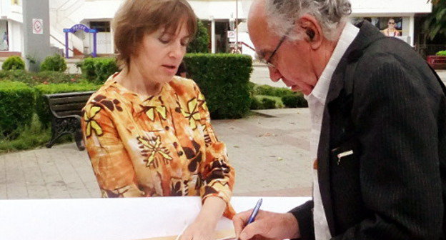  Irina Brovkina's solo picket demanding resignation of Mayor, Anatoly Pakhomov. Residents of Sochi approach her and sign the poster, Sochi, May 17, 2012. Photo by Svetlana Kravchenko for the "Caucasian Knot"