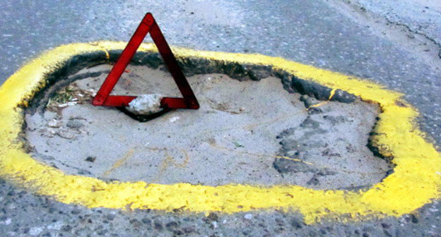 Volgograd fighters for good roads have marked dangerous pits with yellow paint and emergency stop signs; Volgograd, June 28, 2012. Photo by Tatiana Filimonova