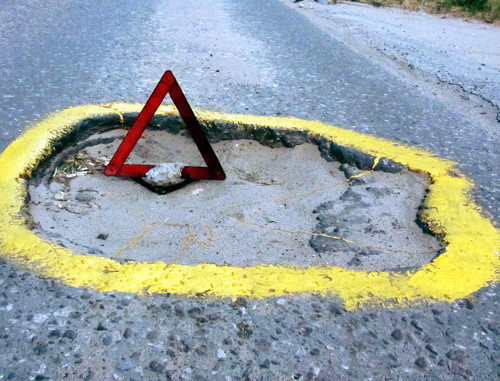 Volgograd fighters for good roads have marked dangerous pits with yellow paint and emergency stop signs; Volgograd, June 28, 2012. Photo by Tatiana Filimonova