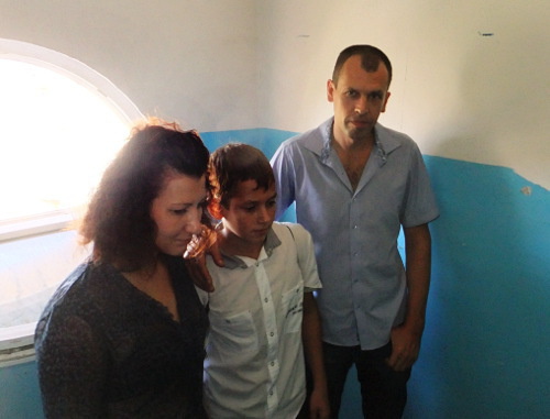  

Elena, Konstantin and Maxim Shablo waiting for court marshals in the doorway of No. 20 Yasnogorskaya Street, Sochi, September 26, 2012. Photo by Svetlana Kravchenko for the "Caucasian Knot"

 