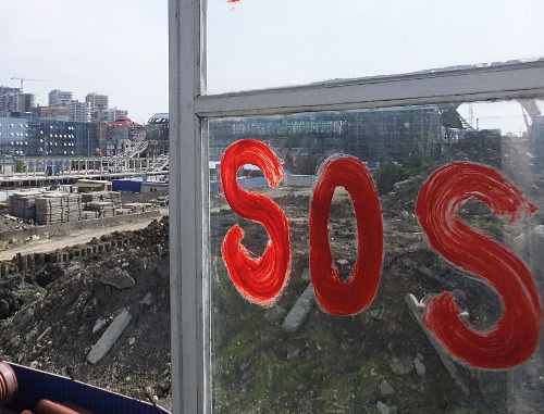 Inscription "SOS" on the window of No. 65 in Prosvescheniya Street immured by builders of MPO "Mostovik" with the aim to force tenants out; Sochi, October 2012. Photo by Svetlana Kravchenko for the "Caucasian Knot"