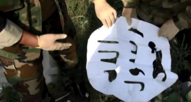 Law enforcers show the militants' flag found at the site of the special operation in the village of Psedakh. August 23, 2017. Photo http://nac.gov.ru