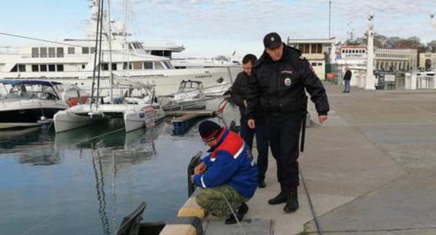 Policeman and fisherman in the Sochi Seaport. Photo by Svetlana Kravchenko for the Caucasian Knot. 