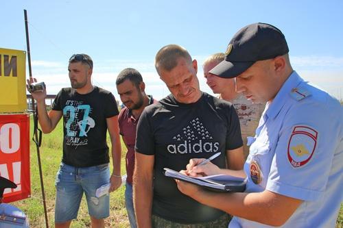 Farmers on protest rally in the Krasnosulin District and a policeman, August 12, 2018. Photo by Vyacheslav Prudnikov for the Caucasian Knot