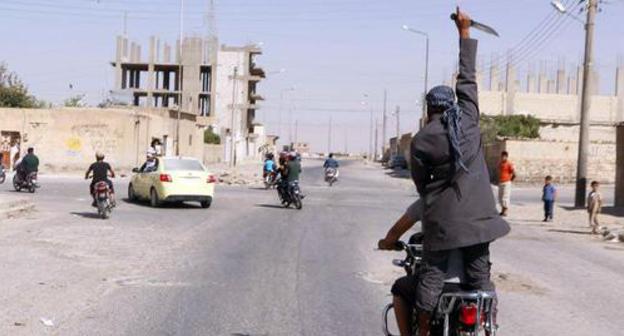 A man holds khife above his head celebrating capture of Tabqa airbase by militants. Photo: REUTERS / Stringer