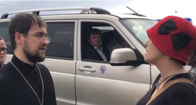 Svetlana Anokhina talks to a priest at the site of the construction of the temple in the park. Screenshot of the video on the YouTube Channel of the "Caucasian Knot"