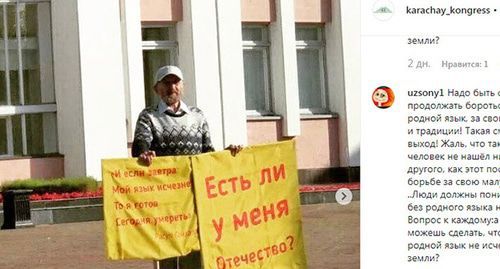 Albert Razin holding posters during a solo picket. Screenshot https://www.instagram.com/p/B2TiGNVgqvI/