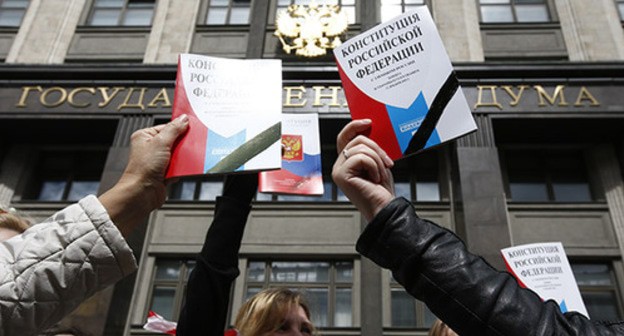 Young people hold the Constitution of Russia near the building of the State Duma. Photo: REUTERS/Sergei Karpukhin