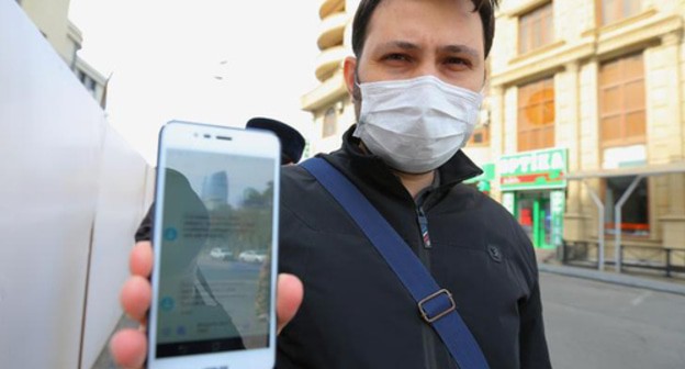 A resident of Baku shows an SMS permit for leaving home. Photo REUTERS/Aziz Karimov