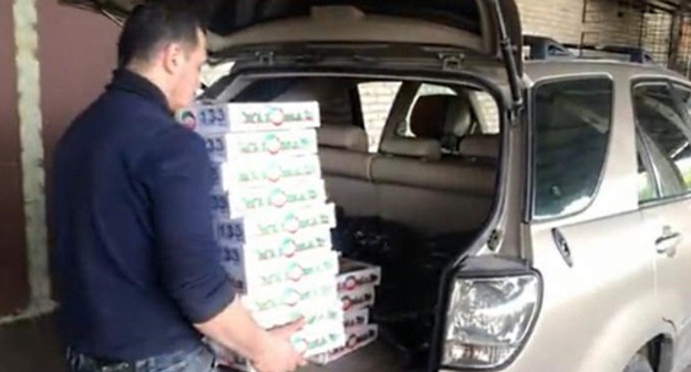 A volunteer loads foodstuff parcels for those in need in a car. Photo by Lyudmila Maratova for the "Caucasian Knot"