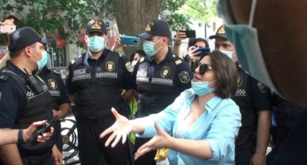 A participant of the action in Baku and police officers. Photo: Açiq mənbələrdən, https://www.contact.az/ext/news/2020/6/free/Social/ru/124913.htm