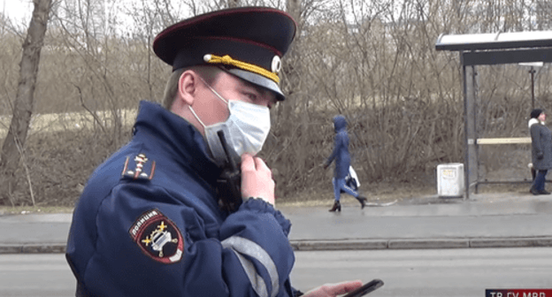 Policeman with smartphone in his hands. Screenshot: https://www.youtube.com/watch?v=NPQgNeW1dGI