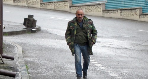 A man walking on street in Stepanakert with an unexploded shell in the background. Photo by Alvard Grigoryan for the "Caucasian Knot"