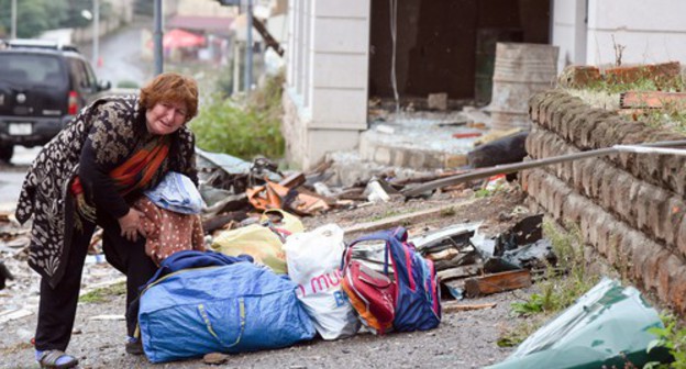 A woman rendered homeless gathers her belongings, October 6, 2020. David Kagramanyan / the information centre of NKR / PAN Photo / Reuters