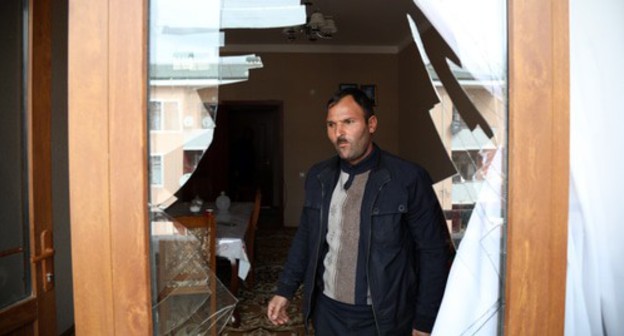 A man standing next to a broken window after shelling, Ganja, October 2020. Photo by Aziz Karimov for the "Caucasian Knot"