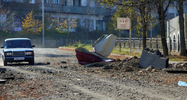 People driving a car near the house damaged in a shelling attack in the city of Shushi (Shusha), October 29, 2020. Photo: Vagram Bagdasaryan/Photolure via REUTERS