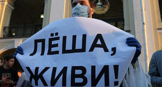 A man holds a poster with the words: "Lesha, be alive!" during a rally in support of the leader of the Russian opposition Alexei Navalny, August 2020. Photo: REUTERS / Igor Russak