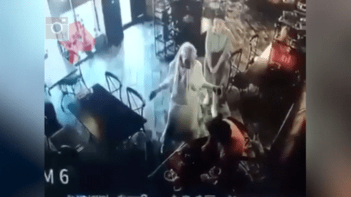 A conflict between Elez Merzhoev (dressed in orange) and Aina Getagazova (dressed in white) in a cafe in Nazran on June 15, 2021. Screenshot of the video https://dni.ru/video/2021/6/17/481045.html