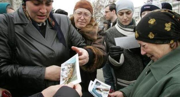 Relatives of the victims in the attack on Nalchik are looking at their pictures. Nalchik, November 29, 2005. Photo: REUTERS/Viktor Korotayev