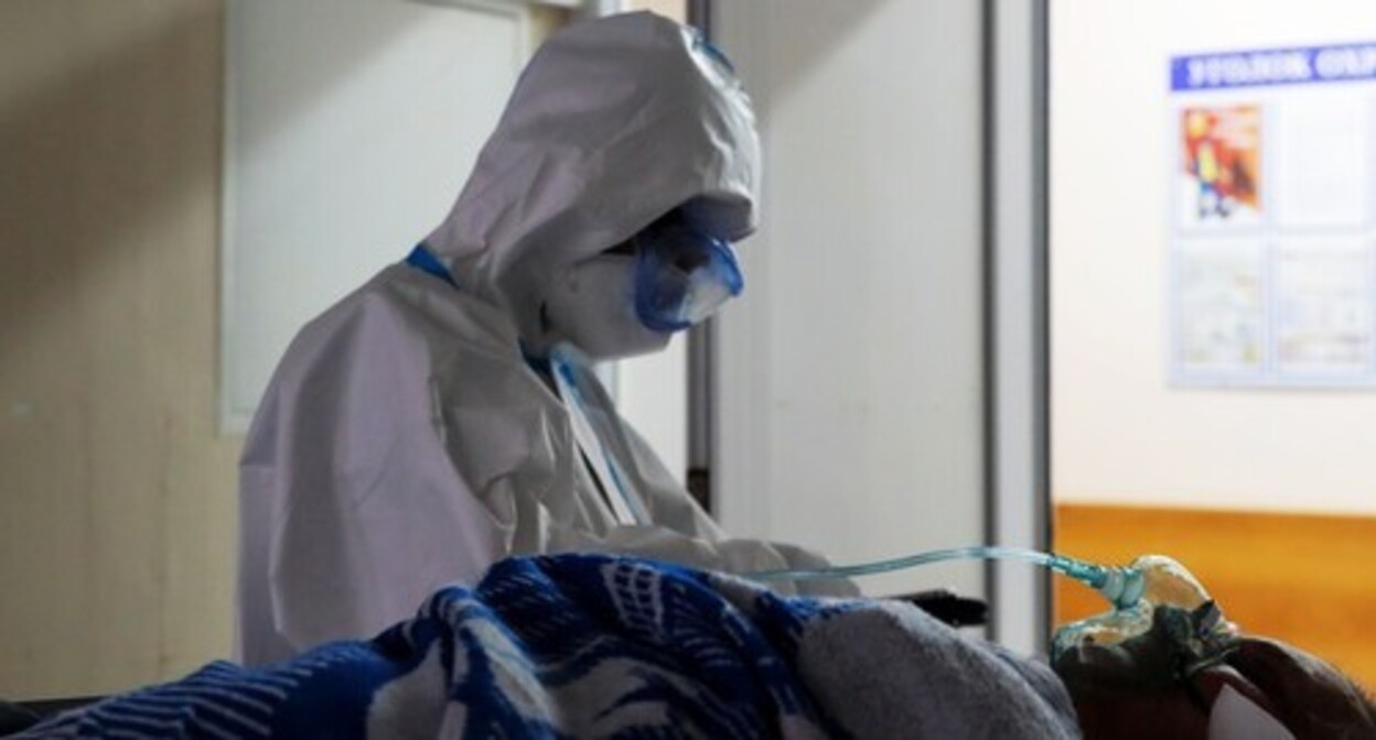 A medical worker near a patient, October 2020. Photo: REUTERS/Maxim Shemetov