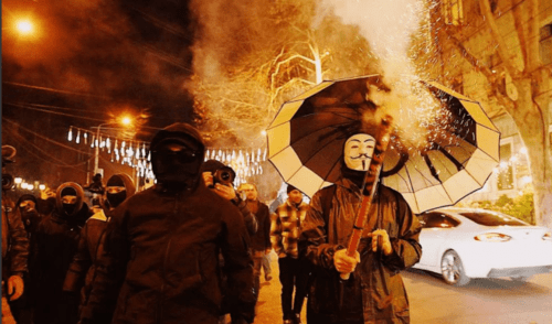 Protesters in masks. Screenshot of a photo posted by Publika on January 18, 2025 https://www.facebook.com/publika.ge/posts/pfbid0gy9s2mivFT515x1ngVSDDcbfyAXkU9oUqbd39zE3YtBiQ1DJr5qDYNemNVuCpYjTl the activities of the Meta Company, owning Facebook, are banned in Russia