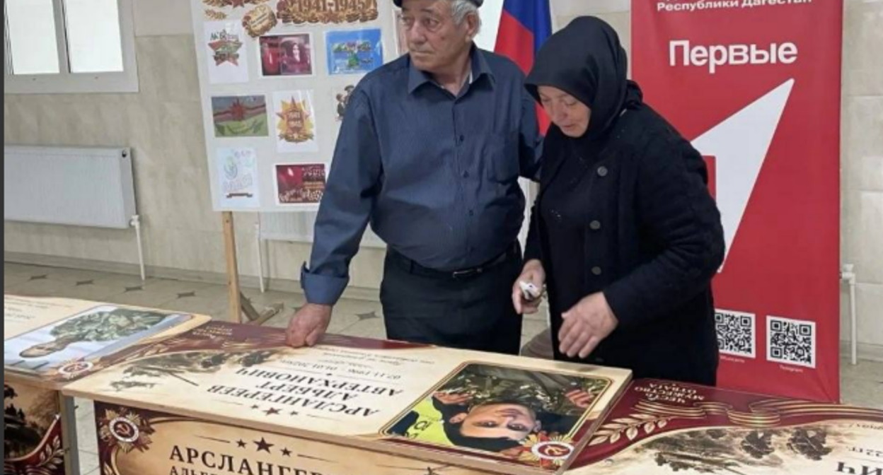 Relatives at the unveiling of a personalized desk. Screenshot from the Babayurt District Administration, May 25, 2026, https://t.me/babayurtrayon/12221?single Relatives at the unveiling of a personalized desk. Screenshot from the Babayurt District Administration, May 25, 2026, https://t.me/babayurtrayon/12221?single